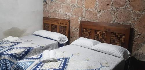 duas camas sentadas uma ao lado da outra num quarto em Cabaña Las Caballerizas em Tecozautla