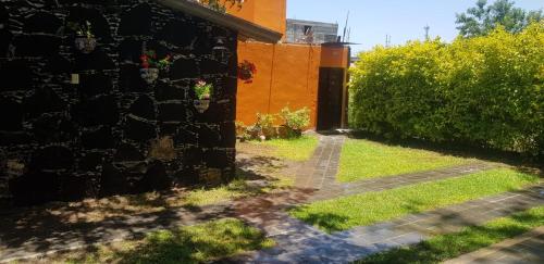uma casa com uma parede de tijolos e um quintal em Cabaña Las Caballerizas em Tecozautla