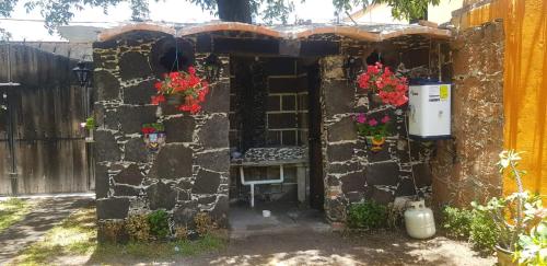 una entrada a un edificio de piedra con un banco en Cabaña Las Caballerizas, en Tecozautla