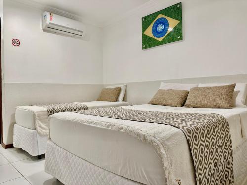a bedroom with two beds and a couch at Vila Jeri Hotel in Jericoacoara