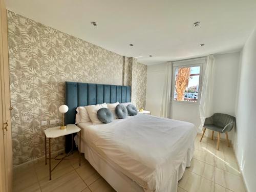 1 dormitorio con 1 cama con cabecero azul en Amarilla Golf Suite by VV Canary Ocean Homes en San Miguel de Abona