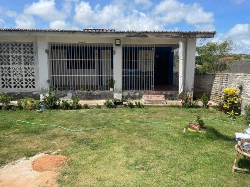 une maison avec un tuyau vert dans la cour dans l'établissement Casa de praia em Muriú, à Ceará-Mirim