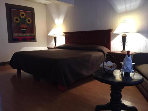 um quarto com uma cama e uma mesa com 2 candeeiros em villa de la plata em Guanajuato