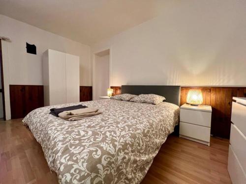 ein Schlafzimmer mit einem großen Bett mit einer braunen und weißen Decke in der Unterkunft La maison de Jean-Pierre  in Devecey