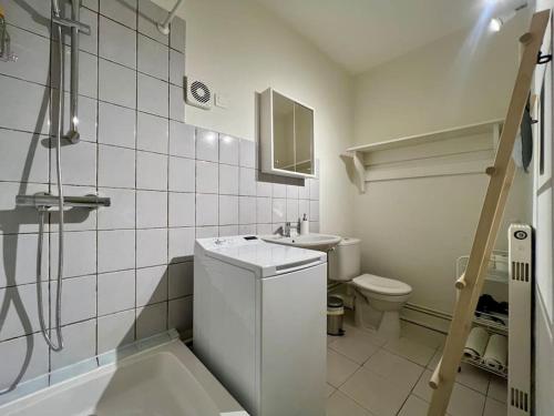 La salle de bains blanche est pourvue d'un lavabo et de toilettes. dans l'établissement La maison de Jean-Pierre , à Devecey