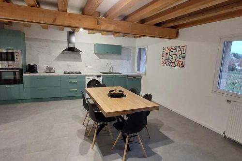 eine Küche mit grünen Schränken und einem Holztisch in der Unterkunft Appartement au pied des Vignes in Vosne-Romanée