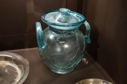 a green glass vase sitting on a glass table at Palazzo Oddo Rental Rooms in Albenga