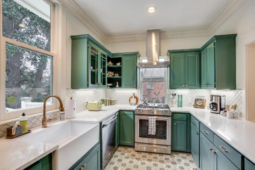 a green kitchen with green cabinets and a sink at 1 Mi to Downtown Tyler Historic Home with Porch! in Tyler