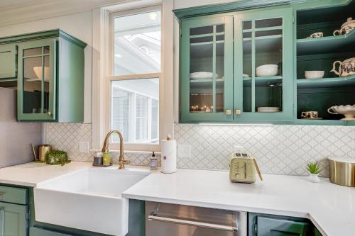 a kitchen with green cabinets and a sink at 1 Mi to Downtown Tyler Historic Home with Porch! in Tyler