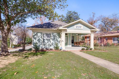a small house with a lawn in front of it at 1 Mi to Downtown Tyler Historic Home with Porch! in Tyler