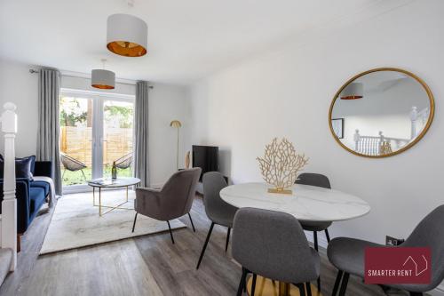 un soggiorno con tavolo, sedie e specchio di Woking, Knaphill - 2 Bed House - Parking & Garden a Brookwood