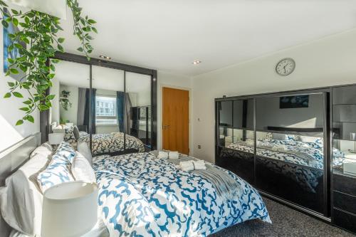 a bedroom with a bed and a large mirror at Corporate Canary Suite in London