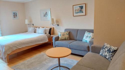 ein kleines Wohnzimmer mit einem Bett und einem Sofa in der Unterkunft Appartement Genigau in Wagrain