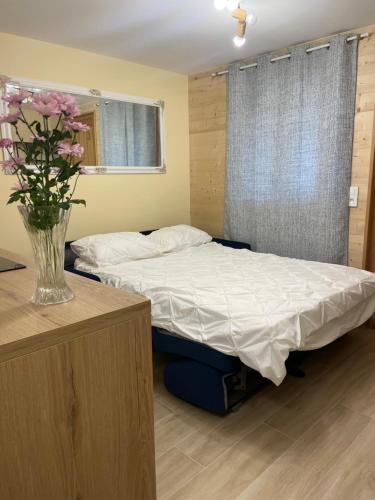 um quarto com duas camas e um vaso com flores em Chalet Lou Via location em Abondance