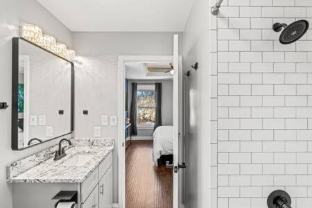 La salle de bains blanche est pourvue d'un lavabo et d'un miroir. dans l'établissement Harvey House - Tranquil Lincoln Park Extended Stay, à Knoxville