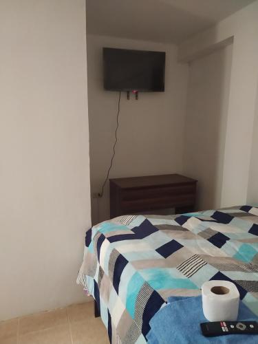 een slaapkamer met een bed en een tv aan de muur bij Nuestro Señor del Camino in Cajamarca