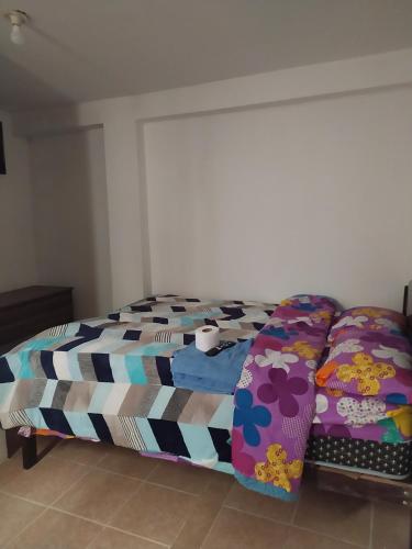 a bedroom with a bed with colorful sheets at Nuestro Señor del Camino in Cajamarca