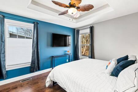 a bedroom with a blue wall and a ceiling fan at Harvey House - Tranquil Lincoln Park Extended Stay in Knoxville