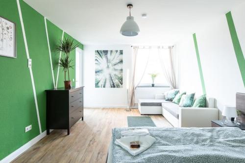 a living room with a bed and a couch at Nature inspiration Apartment with Balcony & Grill BBQ in Duisburg Mitte Central Station 10 Mins & Big TV with Photo Lights in Duisburg