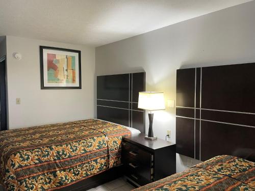 ein Hotelzimmer mit 2 Betten und einer Lampe in der Unterkunft Deerfield Inn in Xenia