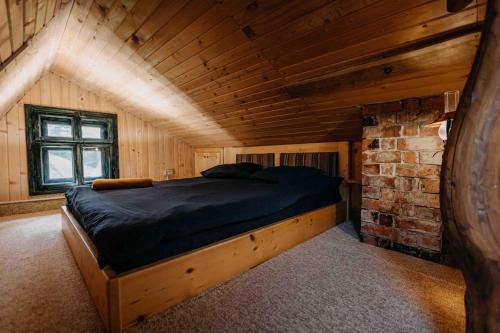 Ce lit se trouve dans une chambre dotée d'un mur en briques. dans l'établissement Mountain View Tiny House, à Lacu Roșu