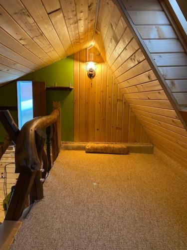 an attic room with a wooden ceiling and a bench at Mountain View Tiny House in Lacu Rosu