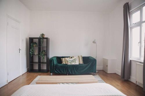 a living room with a green couch in a room at 2 New bed flat in hammersmith in London