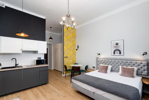 a bedroom with a king sized bed and a kitchen at Wawel Apartments - Old Town in Kraków