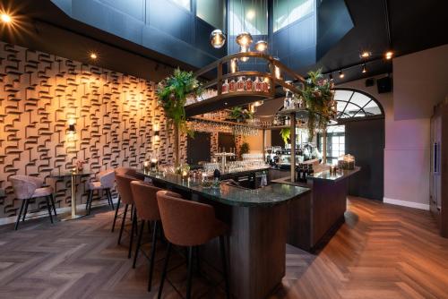 a bar in a restaurant with bar stools at Landgoed Rhederoord nabij Arnhem in De Steeg