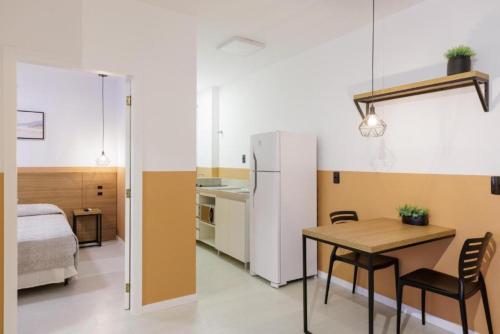 a kitchen and dining room with a table and a bed at Le Village Flats e Hotel in Joinville