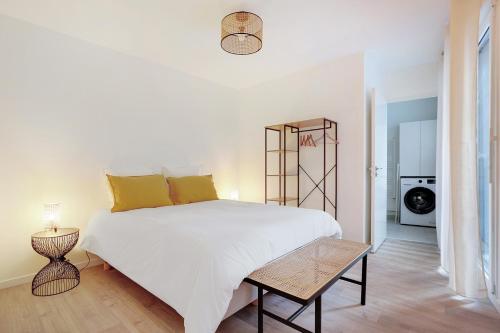 a bedroom with a large white bed with yellow pillows at La Résidence Alpha Viroflay 102 - 1 chambre - 2 pers in Viroflay