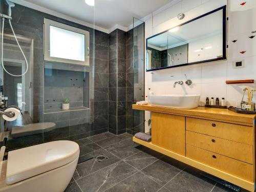 a bathroom with a sink and a toilet at La Casa Di Fiori Stylish Holiday Home in Plataniás
