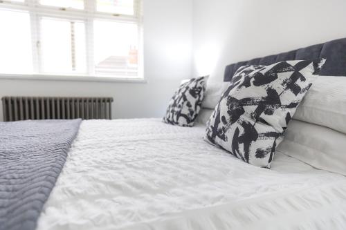 a white bed with black and white pillows on it at Jalebo in Cleethorpes