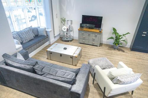 a living room with a couch and chairs and a tv at Jalebo in Cleethorpes