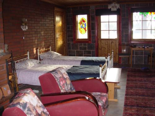 a bedroom with two beds and two chairs at Rinne in Rymättylä