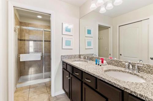 a bathroom with two sinks and a shower at Townhome with Private Pool, BBQ & FREE Waterpark in Kissimmee