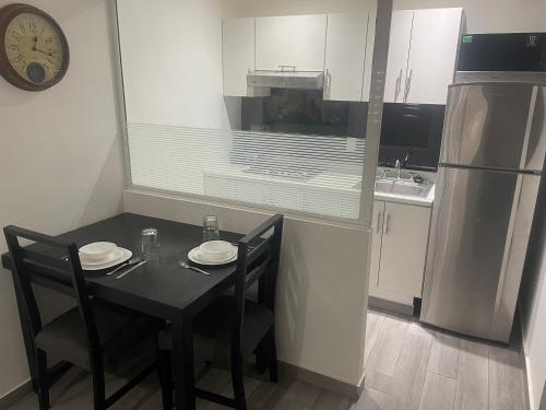 uma cozinha com uma mesa com 2 cadeiras e um frigorífico em European Life Style Executive Suites em Guadalajara