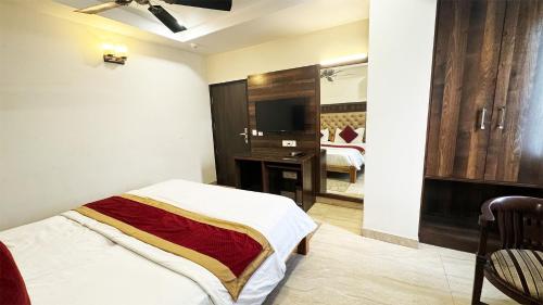 a bedroom with a bed and a television in it at Staybook Hotel Atlanta New Delhi Train Station in New Delhi