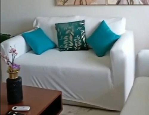 a white couch with three blue pillows on it at Aire acondicionado Parking Llegada autónoma Duermen 8 huespedes in Xochitepec