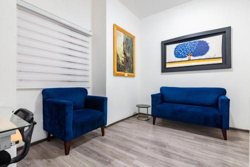 dos sillas azules sentadas en una sala de espera en European Life Style Executive Suites, en Guadalajara