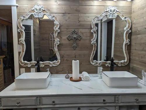 a bathroom with two sinks and two mirrors at Robbins Nest in South Toledo Bend