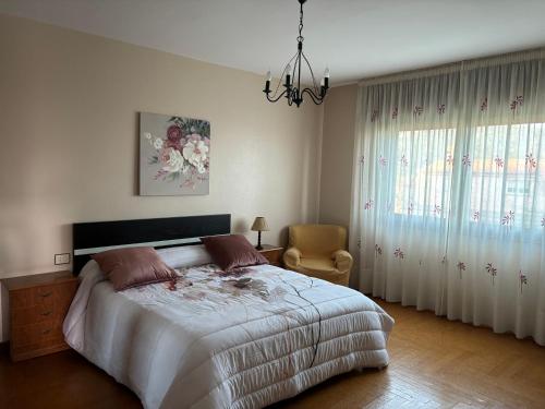 a bedroom with a bed and a chandelier at Chalet As Mimosas in Cangas de Morrazo