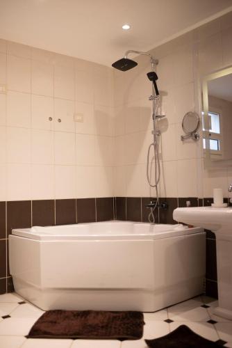 a white bath tub in a bathroom with a sink at Munir’s residence in Cairo