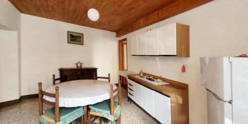 a kitchen with a table and a refrigerator at La corte di via Chiarello in Taceno