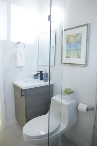 a white bathroom with a toilet and a sink at Apt 4 Miami Designer Apartment in the Upper East-Side in Miami