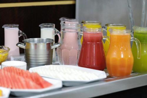 a counter with different types of juice and drinks at Le Village Flats e Hotel in Joinville