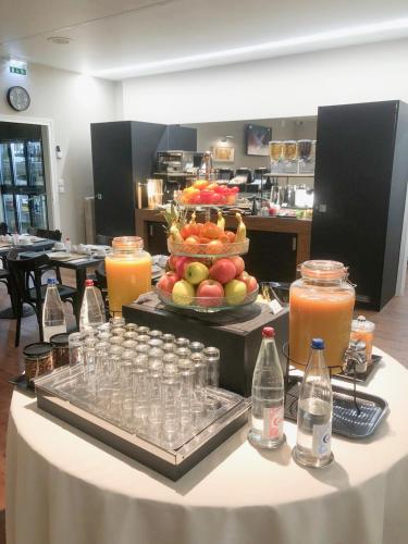Una mesa con una bandeja de comida y bebidas encima. en Grand Hôtel Du Tonneau D'Or, en Belfort