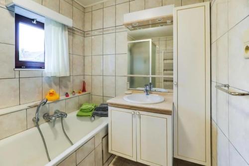a bathroom with a tub and a sink and a shower at Bij Suus onder de wol in Borgloon