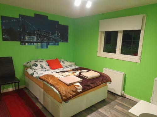 um quarto com uma cama com paredes verdes em Bastolino em Newtongrange