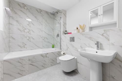 a white bathroom with a sink and a toilet at 3 Bedroom Sleep12 in London MR2 in London